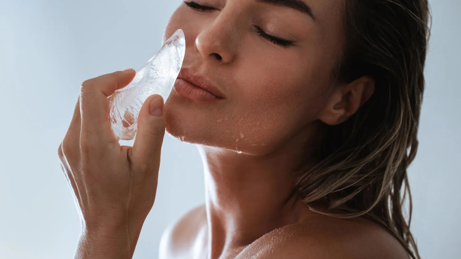 woman rubbing ice on lips