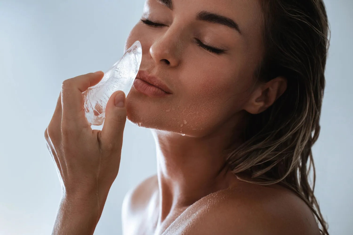woman rubbing ice on lips